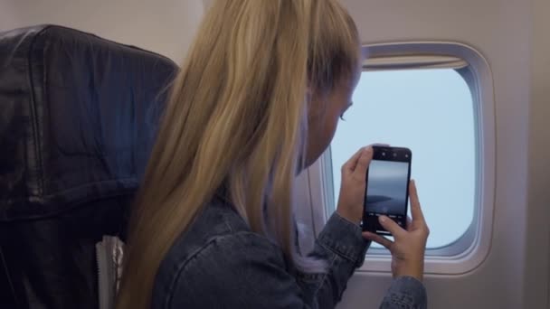 Menina adolescente filmando vista de avião — Vídeo de Stock