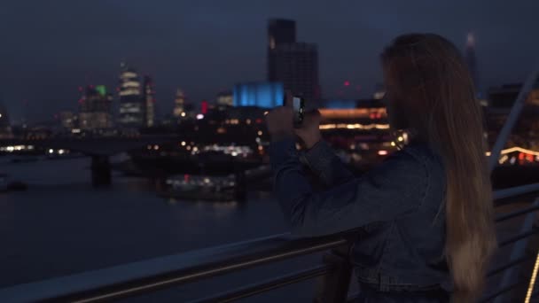 Rubia adolescente turista filmación con teléfono inteligente sobre la ciudad — Vídeo de stock