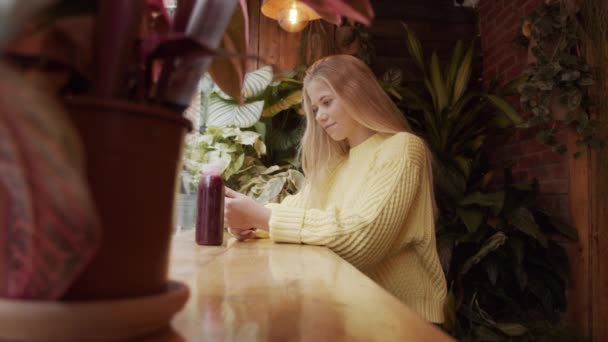 Teenage Blond Girl Looking At Phone In Cafe — Stock Video