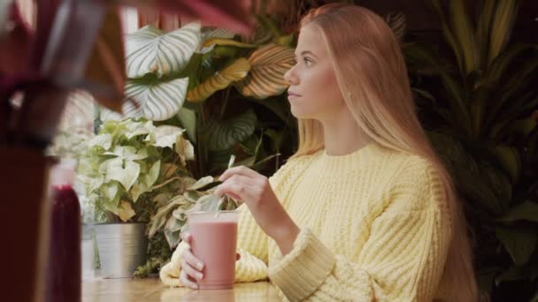 Blond Teenage Girl With Milkshake In Cafe — Stockvideo