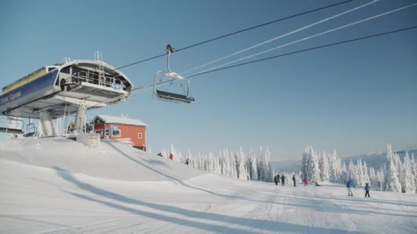 Skilift mit leerem Stuhl fährt über Skipiste — Stockvideo