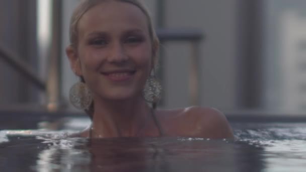 Блондинка плещет водой в камеру — стоковое видео