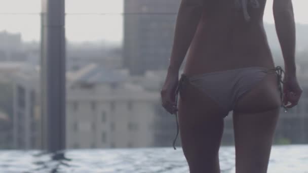 Mujer en bikini entrando en la piscina infinita del hotel — Vídeos de Stock
