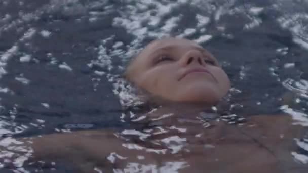 Mulher bonita nadando de volta na piscina do hotel — Vídeo de Stock