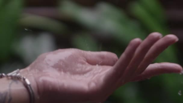 La mano de la mujer salpicada por la lluvia cayendo — Vídeos de Stock
