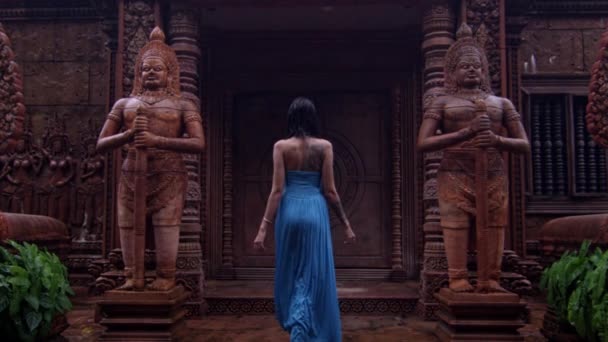 Junge Frau in blauem Kleid betritt thailändischen Tempel — Stockvideo
