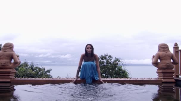 Kvinna i blått stänk vatten från templet Poo — Stockvideo