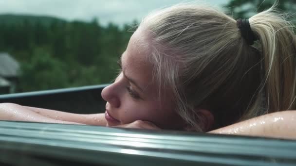 Женщина отдыхает в горячей ванне на открытом воздухе — стоковое видео