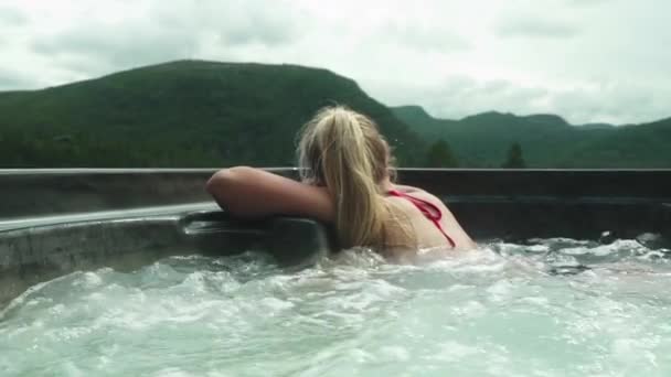 Blond vrouw ontspannen in bubbelende jacuzzi — Stockvideo