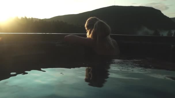 Vrouw ontspannen in jacuzzi bij zonsondergang — Stockvideo