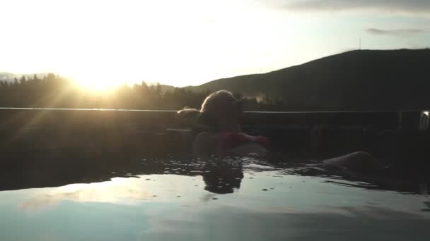 Junge Frau entspannt sich im Whirlpool bei Sonnenuntergängen — Stockvideo