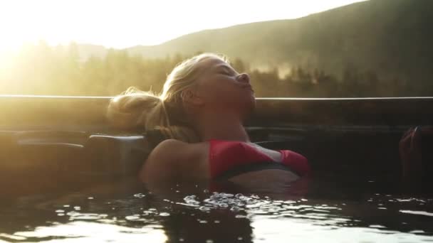 Mujer retrocediendo en bañera de hidromasaje humeante — Vídeo de stock