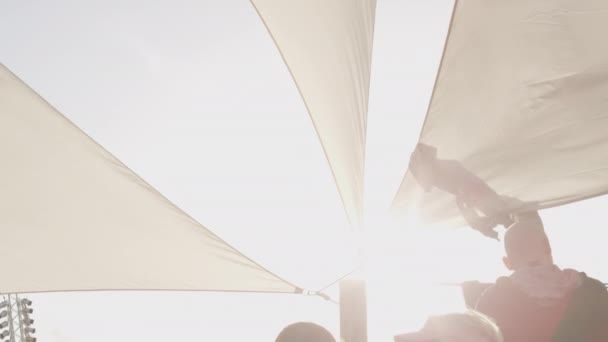 Солнечная вспышка и белая палатка на корабле в ветреный день во время фестиваля — стоковое видео