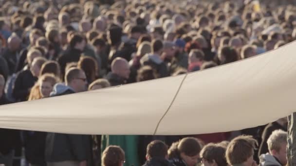 Ruha sátor tetőn, hogy fújja a szél és az emberek a háttérben — Stock videók