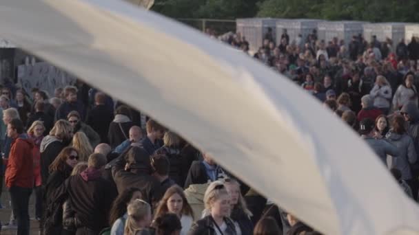 Tentdoek op de voorgrond en menigte van mensen op de achtergrond — Stockvideo