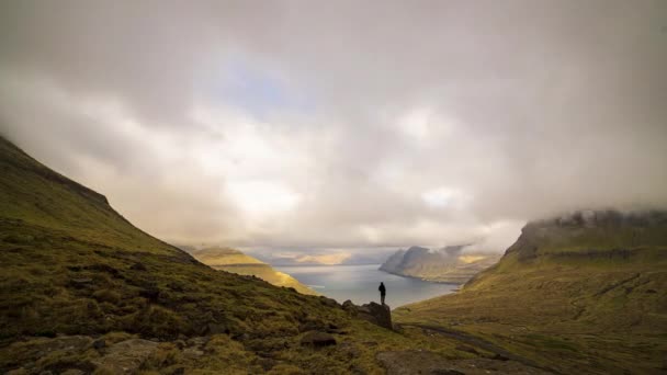 Hombre viendo nubes moverse sobre el paisaje — Vídeo de stock