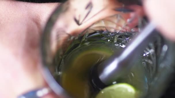 调酒师混合鸡尾酒并从玻璃杯中提取柑橘 — 图库视频影像