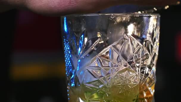 Человек кладет лед на стекло перед разливом алкоголя — стоковое видео