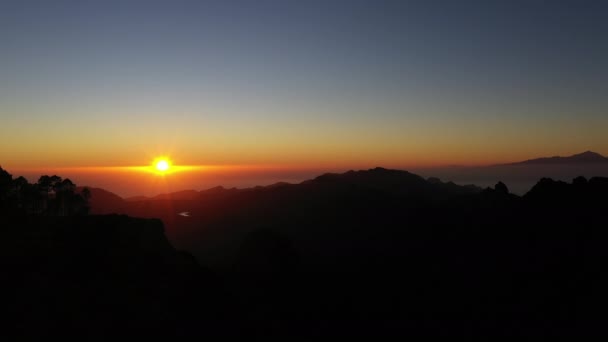Homem nas montanhas observando o pôr do sol — Vídeo de Stock
