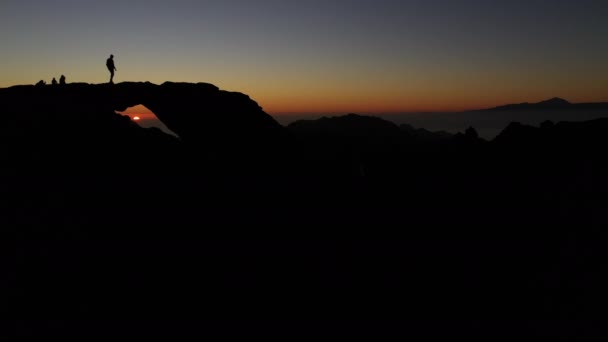Silueta de la gente viendo la puesta de sol de la montaña — Vídeo de stock