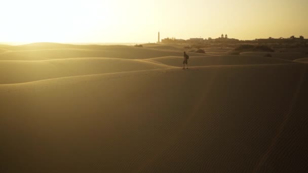 Muž kráčející po písečných dunách v poušti — Stock video