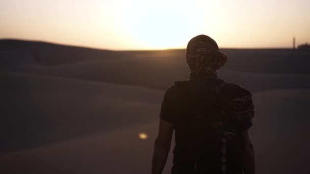Uomo in piedi nel deserto illuminato dal sole — Video Stock