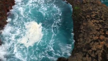 Deniz suyu çarpıyor ve büyük kaya havuzunda hareket ediyor.