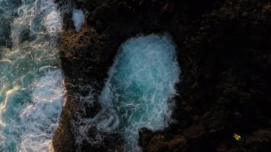 Kıyı şeridinde kaya havuzunun yanında duran adam