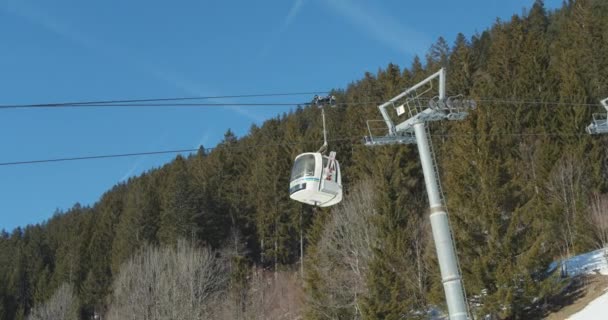 Канатная дорога висит над снежными Альпами и голубым небом — стоковое видео