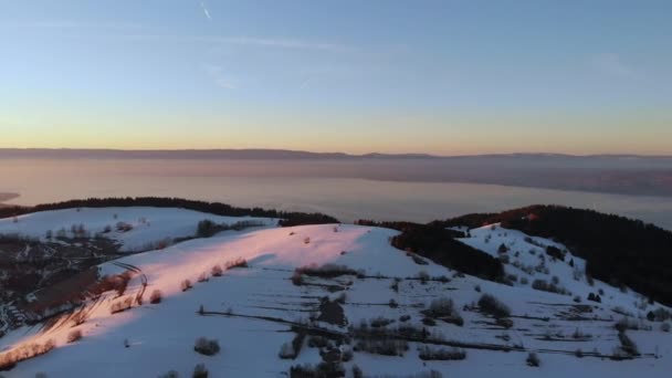 Vista a volo d'uccello dei campi montagnosi innevati e dell'alba — Video Stock