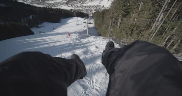 POV człowieka w kolejce linowej ze śnieżnymi dolinami otoczony drzewami — Wideo stockowe