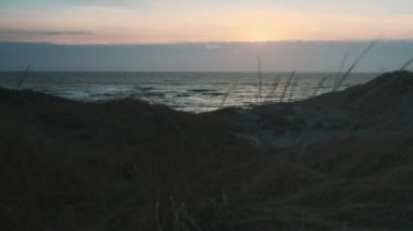 Denizin üstünde gün batımı ve kumsal