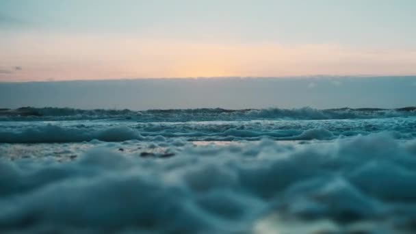 Olas y espuma en la orilla al atardecer — Vídeo de stock