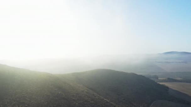 Gyönyörű drón lövés mezők és hegyek borította köd — Stock videók