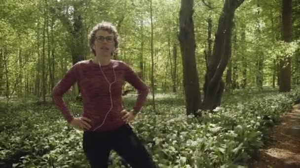 Vrouw met handen op haar taille rusten na joggen in het bos park — Stockvideo