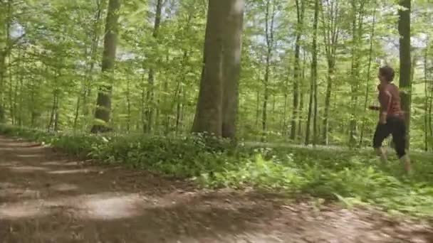 Coureur déterminé au milieu de la forêt Esquiver les branches d'arbres de frapper sa tête 