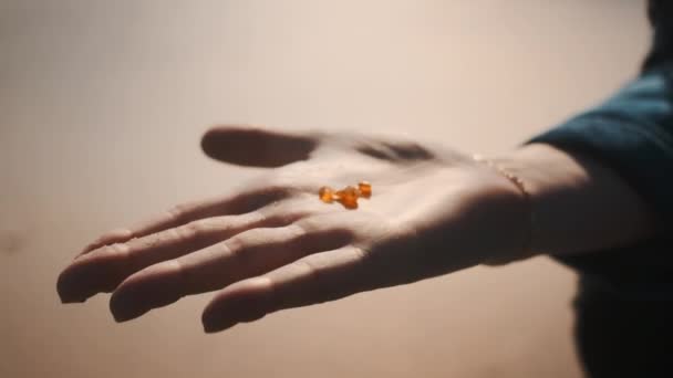 Shot of Three Tiny and Beautiful Amber Sitting on Top of a Woman 's Palm — стоковое видео