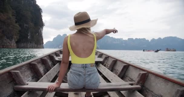 Mulher em um barco viajando pelo lago Chew Lan acenando para um grupo de pessoas — Vídeo de Stock