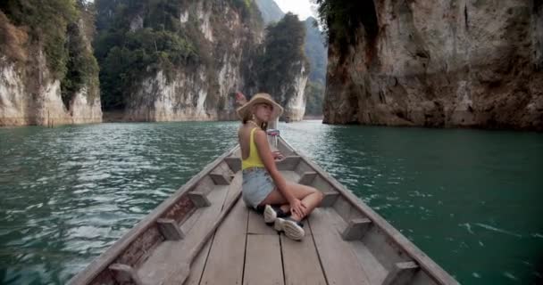 Blondynka model siedzi na podłodze łodzi uśmiechnięty podczas korzystania z Green Lake Water — Wideo stockowe