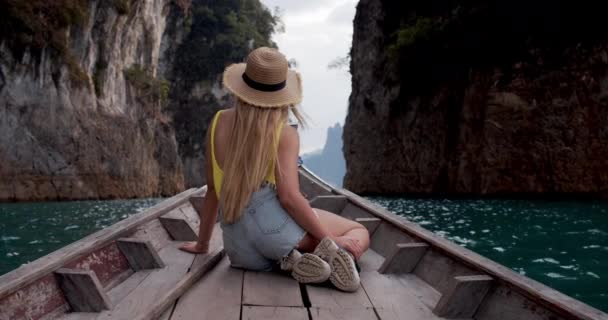 タイの2つの背の高い崖の間の湖を通過するボートに乗る女性 — ストック動画