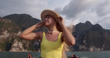 Gölün kıyısında, Hasır Şapkasını Tutan Bir Teknede Bir Kadın ve Dağlar Manzarası