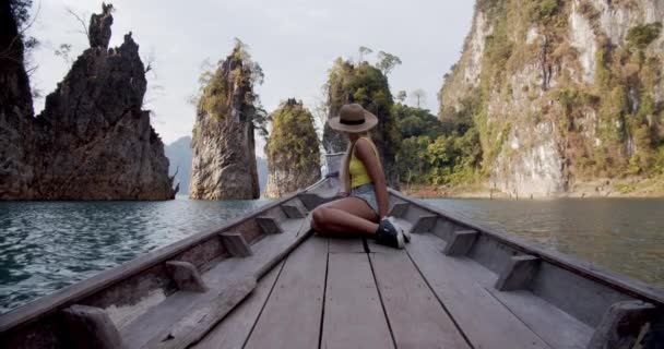 바위와 절벽의 웅장 한 광경으로 보트를 타고 달리는 여자 — 비디오