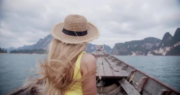 Mulher de volta com longo cabelo loiro sendo soprado pelo vento durante passeio de barco pelo lago — Vídeo de Stock