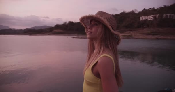 湖畔の波止場を眺めながら一人で歩く女性旅行者 — ストック動画