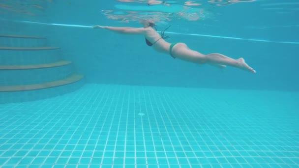 Clip subacquea di femmina con lei sopra l'acqua che nuota in bikini rosso — Video Stock