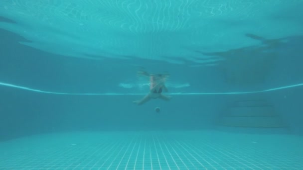 Inyección submarina del cuerpo de la mujer nadando hacia la cámara en la piscina — Vídeo de stock