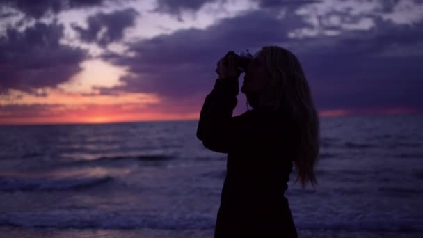 Φωτογράφος σε σιλουέτα στην παραλία στο ηλιοβασίλεμα — Αρχείο Βίντεο