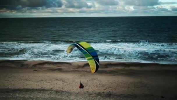 Mężczyzna paralotniarstwo nad plażą — Wideo stockowe