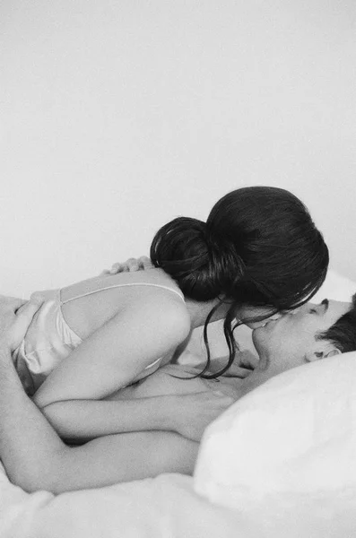 Frau liegt auf Mann und küsst ihn — Stockfoto