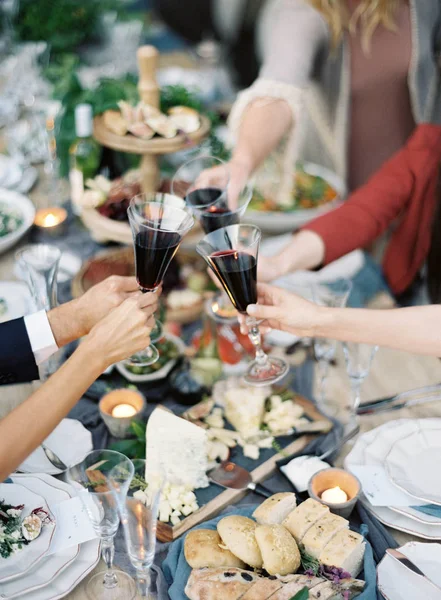 People clincking glasses at setting table — Stock Photo, Image